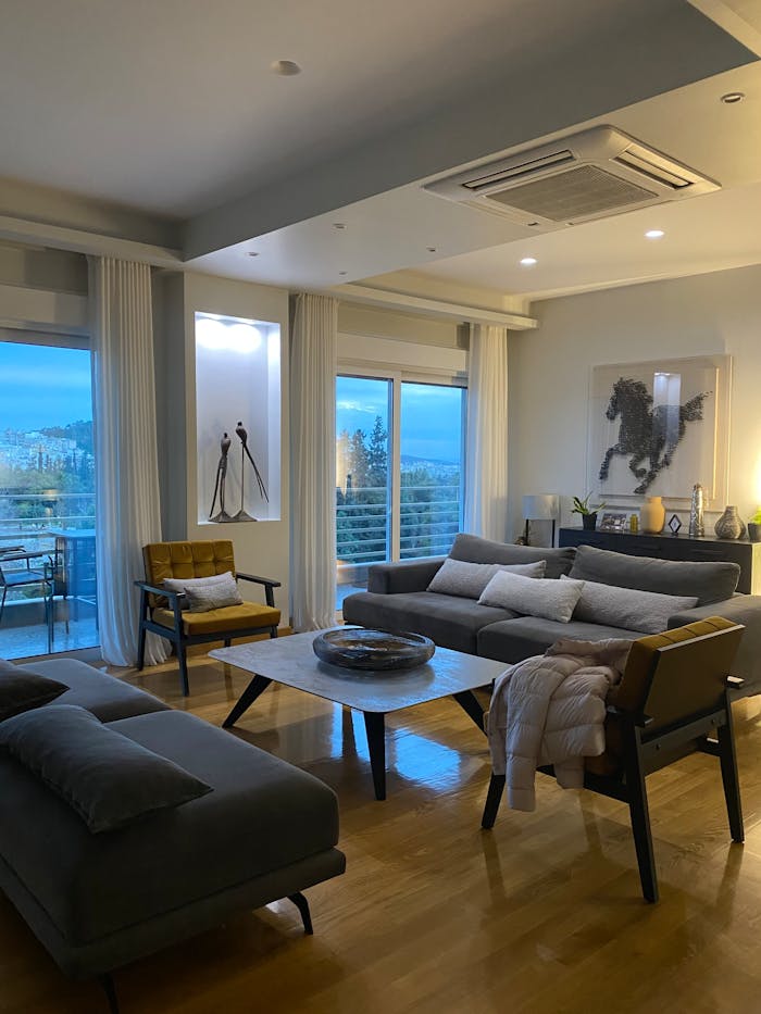 Stylish living room with modern decor and a balcony view at sunset.